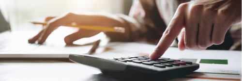 une main sur une calculatrice, fais des opérations de dissolution 